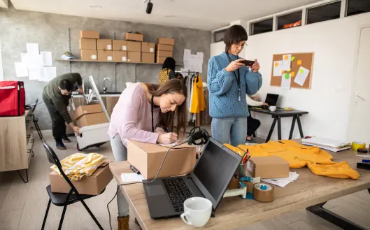 A small business owner is working with their teammates for packaging in their office.